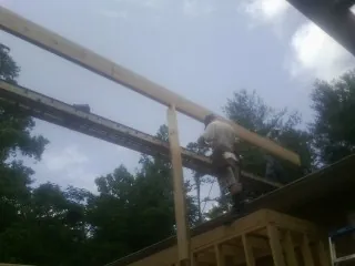 Carpenter setting a ridge beam over a new addition frame — Ice Dam Removal by Roofing Brothers in Summit Lake