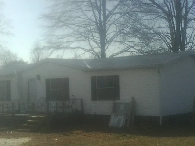 New metal roof on a white painted brick home on a foggy morning in Summit Lake