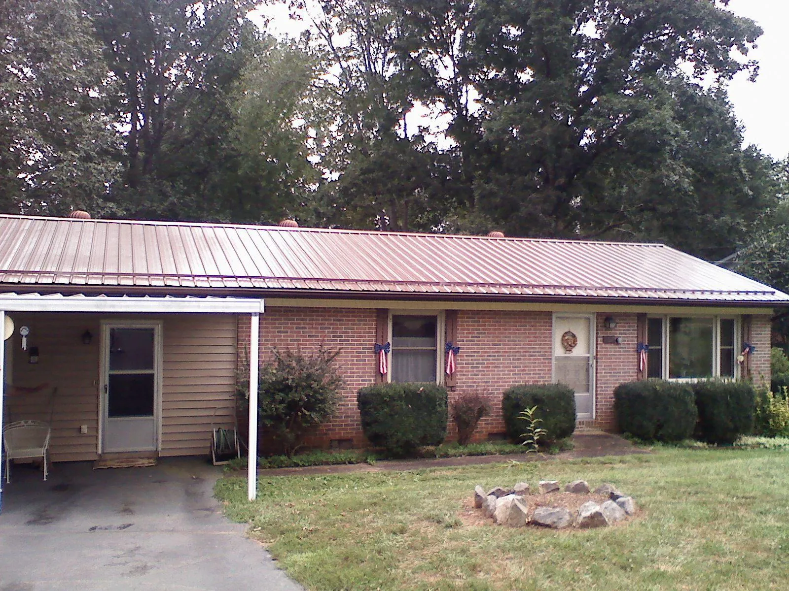 Bronze metal roof and carport on a brick ranch home — Roof Repair work by our crew in Summit Lake