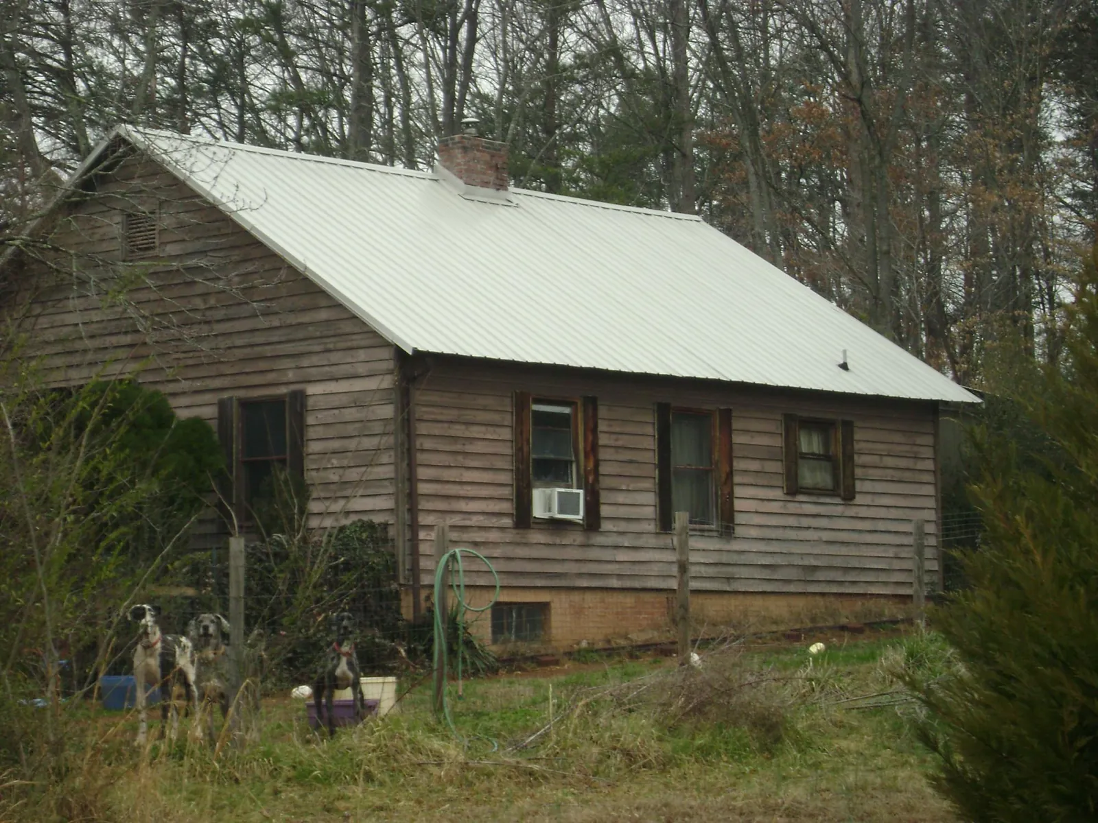 White metal roof on an old wood sided farmhouse, from a Metal Roof Installation job in Summit Lake